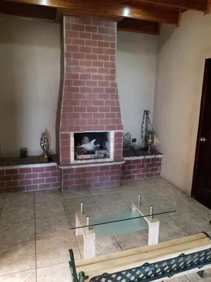 a brick fireplace in a living room with a glass table at Hotel Monte Campana Escazu in San José