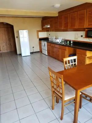 a kitchen with a table and a refrigerator at Hotel Monte Campana Escazu in San José
