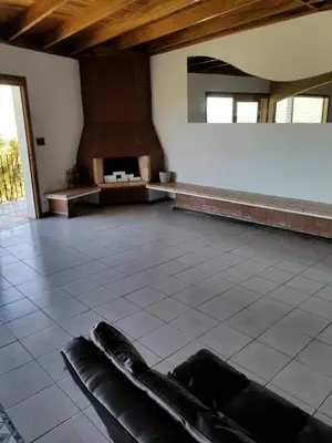 a room with a fireplace and a couch on a tile floor at Hotel Monte Campana Escazu in San José