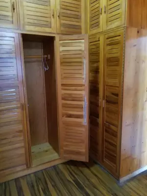 a walk in closet with wooden cabinets and a shower at Hotel Monte Campana Escazu in San José