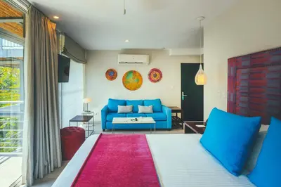 a living room with a bed and a blue couch at Jungle Vista Boutique Hotel in Manuel Antonio
