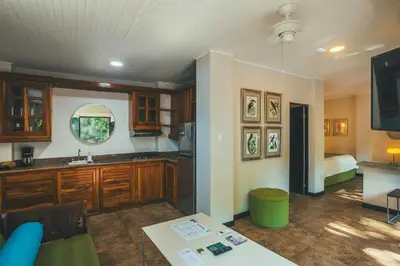 a kitchen with wooden cabinets and a bed at Jungle Vista Boutique Hotel in Manuel Antonio