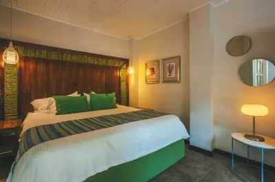a bedroom with a large bed with green pillows at Jungle Vista Boutique Hotel in Manuel Antonio