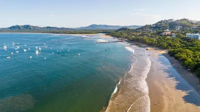 an aerial view of a beach with boats in the water at The Coast Beachfront Hotel in Tamarindo