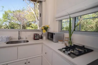 a white kitchen with a sink and a microwave at Moana Surf Resort in Nosara