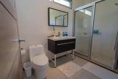 a bathroom with a toilet and a sink and a shower at Moana Surf Resort in Nosara