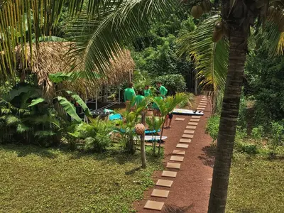 a group of people standing in a garden at Moana Surf Resort in Nosara