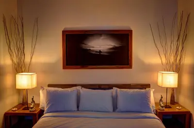 a bedroom with a bed with two lamps and a picture on the wall at Moana Surf Resort in Nosara