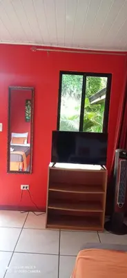 a bedroom with a red wall and a mirror at Hotel Your House in Alajuela City