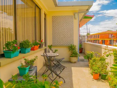 a balcony with a table and potted plants at Hotel Bamboo Aeropuerto in Alajuela City
