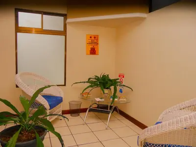 a room with two chairs and a table with a plant at Hotel Bamboo Aeropuerto in Alajuela City
