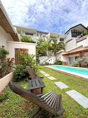 a bench sitting in the grass next to a house at La Ramona Charming Hotel in Tamarindo
