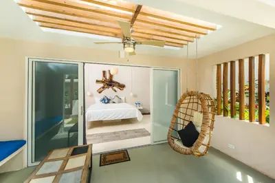 a room with a hammock and a bedroom at La Ramona Charming Hotel in Tamarindo