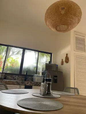 a dining room with a table and a large window at La Ramona Charming Hotel in Tamarindo
