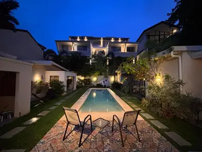 a house with a swimming pool at night at La Ramona Charming Hotel in Tamarindo