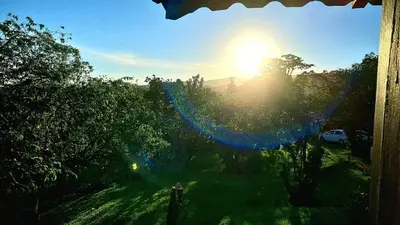a view of the sun rising over a field with trees at Los Gallitos Eco Lodge in San Miguel