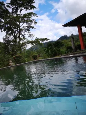 a swimming pool in front of a house at Los Gallitos Eco Lodge in San Miguel