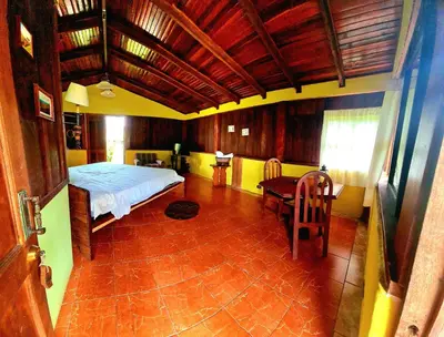 a bedroom with a bed and a table in a room at Los Gallitos Eco Lodge in San Miguel