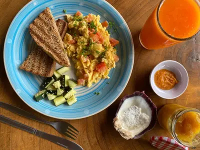 a blue plate of food with toast and vegetables and a drink at Alouatta Playa Coyote in San Francisco