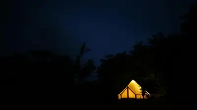 a lit up tent in the dark at night at Alouatta Playa Coyote in San Francisco