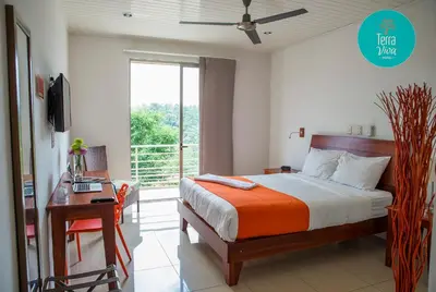 a bedroom with a bed and a desk and a window at Hotel Terra Viva in Quesada