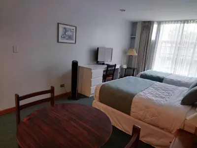 a hotel room with a bed and a table at Apartotel Tairona in San Pedro