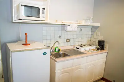 a small kitchen with a sink and a microwave at Apartotel Tairona in San Pedro