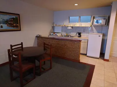a kitchen with a table and a refrigerator at Apartotel Tairona in San Pedro