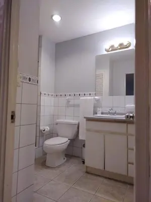 a white bathroom with a toilet and a sink at Apartotel Tairona in San Pedro