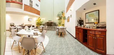 a restaurant with tables and chairs in a room at Apartotel Tairona in San Pedro