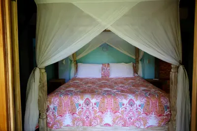 a bedroom with a bed with a canopy at Uvita Bali Bosque Retreat in Uvita