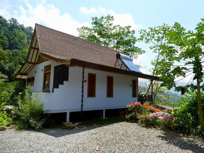 a small white house with a brown roof at Uvita Bali Bosque Retreat in Uvita