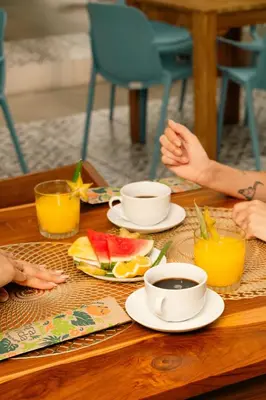 a group of people sitting around a table with food at Wide Mouth Frog Quepos in Manuel Antonio