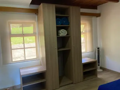 a book shelf in a room with a window at Los Héroes in Nuevo Arenal