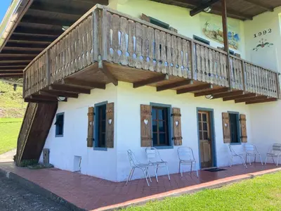 a deck on the side of a building with chairs at Los Héroes in Nuevo Arenal