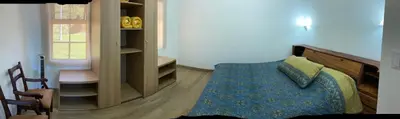 a bedroom with a bed with a blue comforter at Los Héroes in Nuevo Arenal
