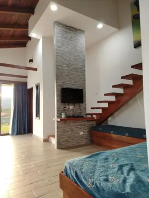 a bedroom with a staircase and a tv and a bed at Los Héroes in Nuevo Arenal