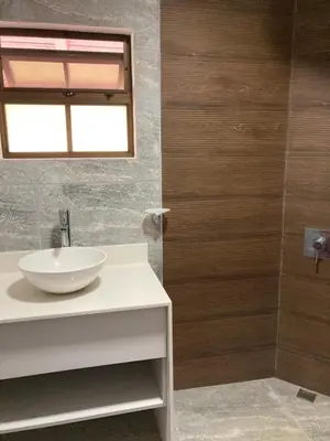 a bathroom with a sink and a mirror and a shower at Los Héroes in Nuevo Arenal