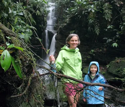 a woman and a child standing in front of a waterfall at Volare in Turrialba