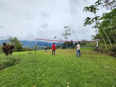 a group of people playing volleyball in a field at Volare in Turrialba