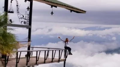 a woman jumping in the sky above the clouds at Volare in Turrialba