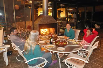 a group of people sitting around a table with a fireplace at Volare in Turrialba