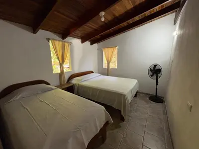 a bedroom with two beds and a fan in it at Casa Susen in Montezuma