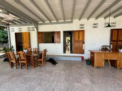 a dining room with a table and chairs and a kitchen at Casa Susen in Montezuma