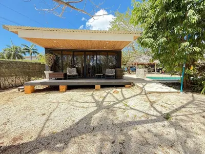 a pavilion with a table and chairs next to a pool at Nirvana Beach Home in Paraíso
