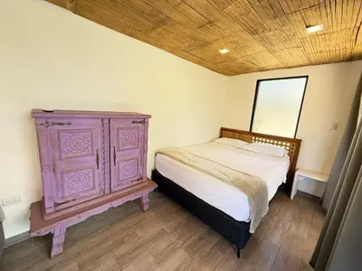 a bedroom with a bed and a wooden dresser at Nirvana Beach Home in Paraíso