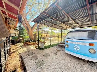 an old van parked under a garage with a roof at Nirvana Beach Home in Paraíso