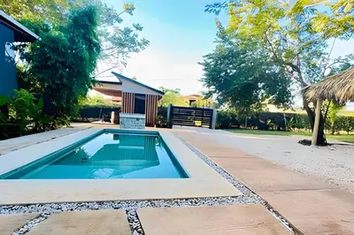 a swimming pool in front of a house at Nirvana Beach Home in Paraíso