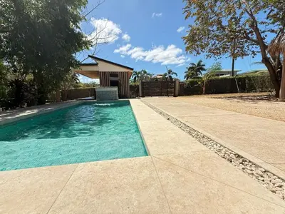 a swimming pool in a yard next to a house at Nirvana Beach Home in Paraíso