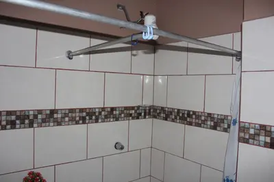 a bathroom with a ceiling fan and tiled walls at Hotel Pecos Bill in San José